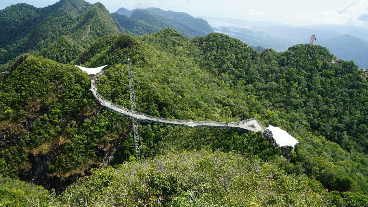 Langkawi Sky Bridge suspended over lush green mountains, offering panoramic views of the tropical island landscape.