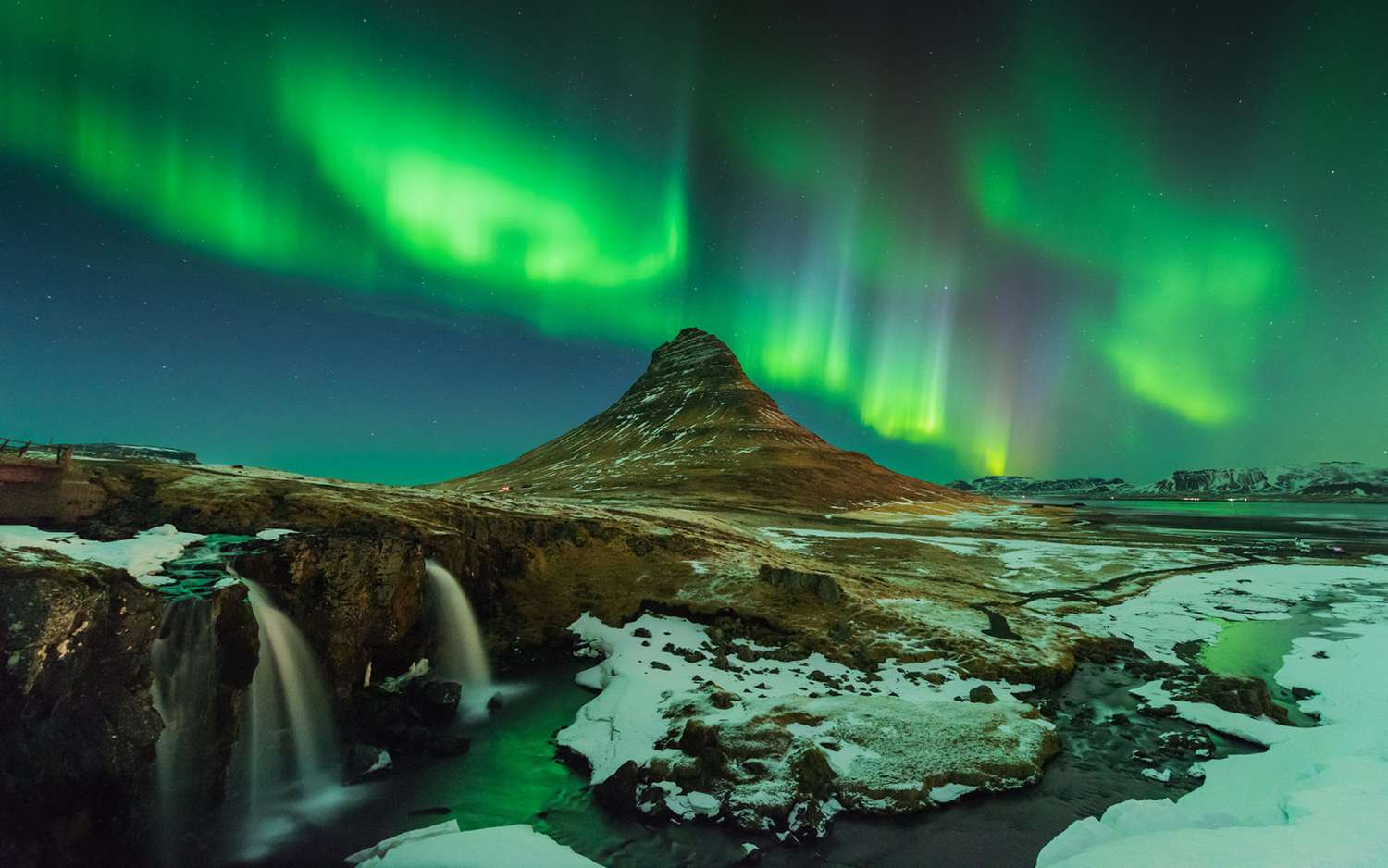 Aurora Borealis over a glacier and rugged landscape in Iceland